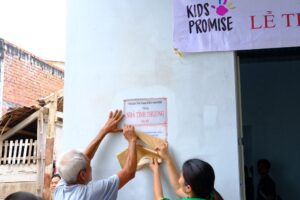 Chủ nhà cùng thành viên nhóm Kids Promise thực hiện khai mở số hiệu nhà